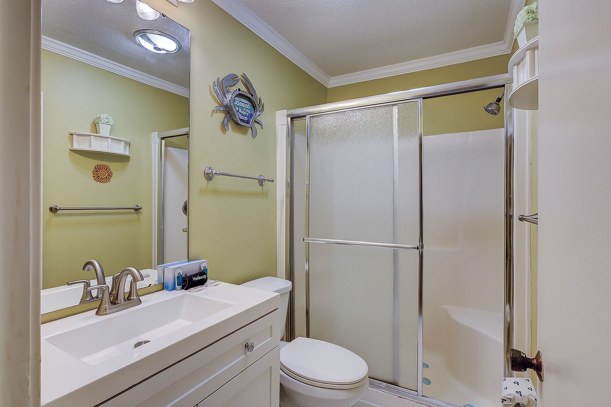 A bathroom with a shower, a sink, and a toilet.