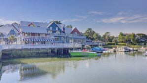 Un bâtiment situé au bord de l’eau, doté d’un quai, d’un bateau vert baptisé « Papasail » et surplombant un lac paisible.