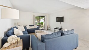 Een moderne woonkamer met een bank, salontafel en een flatscreen televisie.