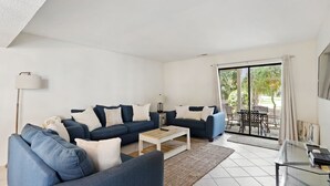 Een moderne woonkamer met een modulaire bank, een bijzettafeltje en een glazen tafel met een lamp.