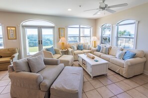 A spacious living room with a large sofa set, a coffee table, and a ceiling fan. - Villas at Santa Rosa #A102 - Location, location, location. (Santa Rosa Beach)
