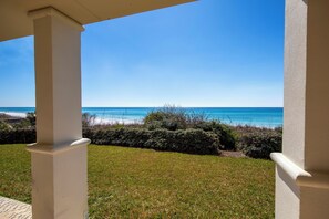 A view from a covered outdoor area overlooking a beach with clear skies. - Villas at Santa Rosa #A102 - Location, location, location. (Santa Rosa Beach)