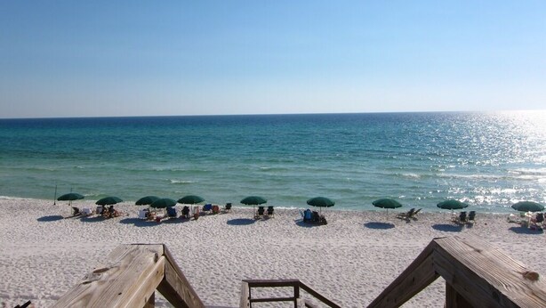 A beach with wooden walkways, green umbrellas, and beach chairs. - Gulf front condo, 1st floor- walk out to beach, Pool, Santa Rosa beach (Santa Rosa Beach)