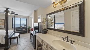 A modern bathroom with a large vanity, a freestanding bathtub, and a ceiling fan. - Broadmoor 105 by Liquid Life (Orange Beach)