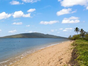 Enjoy a tranquil beach experience with gentle waves lapping at the shore.