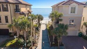 A residential street with houses, palm trees, and a view of the beach. - Casa Lontano - Luxury Home Near the Beach with Gulf Views & Shared Pool (Destin)