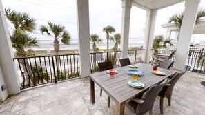 Enjoy al fresco dining on the covered terrace with a view of the beach and palm trees.