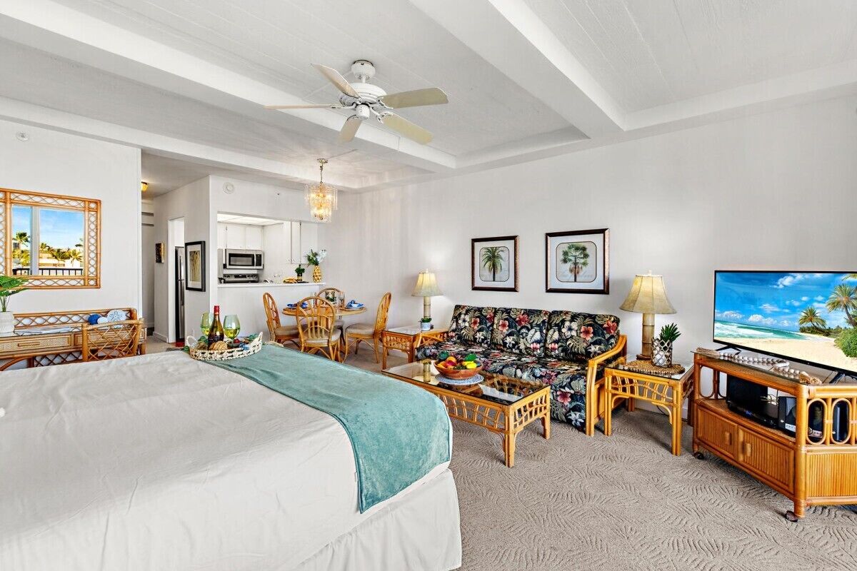 Ein Hotelzimmer mit Bett, Sofa, Essbereich und Fernseher.