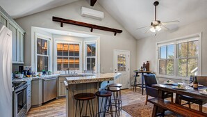 A spacious kitchen with a large island, bar stools, a dining table with chairs, and a ceiling fan. - Epic Home Just Steps to Main Street + Hot tub (Park City)