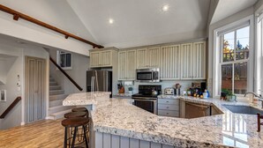 A kitchen with granite countertops, stainless steel appliances, and a large window. - Epic Home Just Steps to Main Street + Hot tub (Park City)