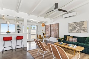 A modern living space with a dining area, seating, and artwork.
