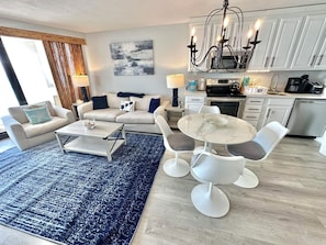 Uma sala de estar moderna com sofá, mesa de centro e espaço de jantar.