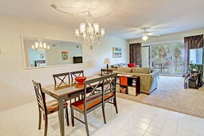 Relax in this spacious living area with a dining table for four, comfortable sofa, and large TV.
