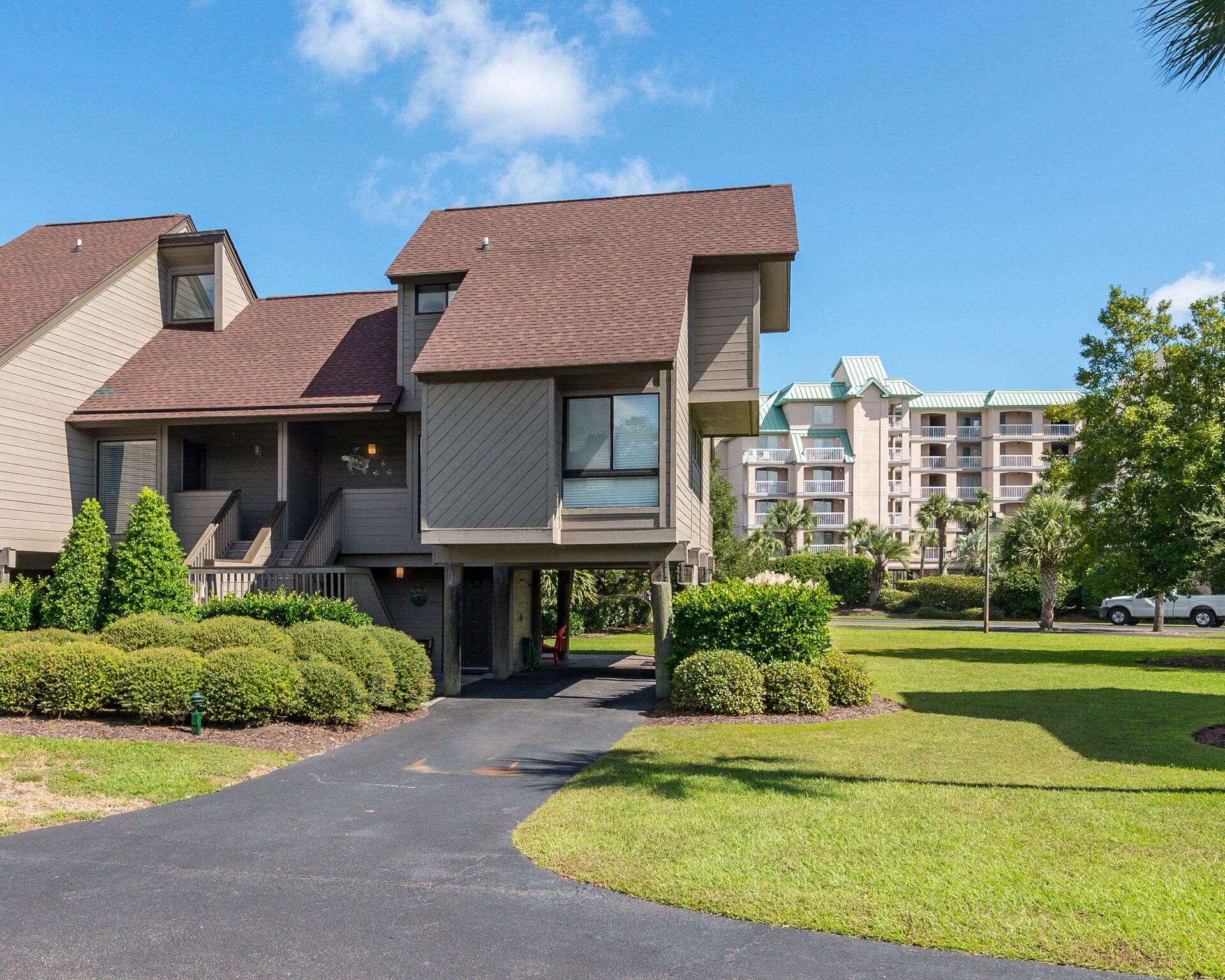 A two-story building with a covered walkway, surrounded by well-maintained lawns and trees.