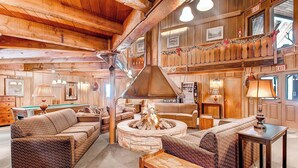 A cozy, rustic interior with a stone fireplace, wooden beams, and a billiards table. - Cozy, Corner Top Floor Unit in Perfect Downtown Location | PM8B (Breckenridge)