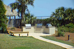 An outdoor barbecue area with a grill, a built-in oven, and a seating bench.