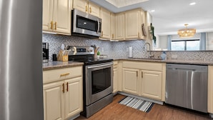 Una cocina moderna con electrodomésticos de acero inoxidable, armarios color beige y un salpicadero decorativo.