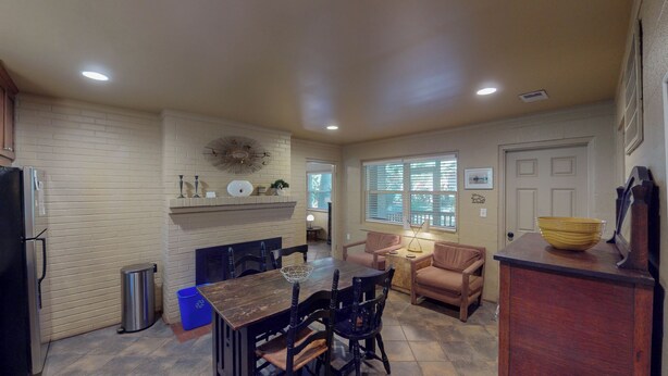 A kitchen with a dining table, chairs, a refrigerator, and a trash can. - Millican North - B 2 bedrooms, 2 bathrooms (Jekyll Island)