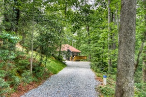Escape to a secluded cabin surrounded by lush forest and a wooden deck.