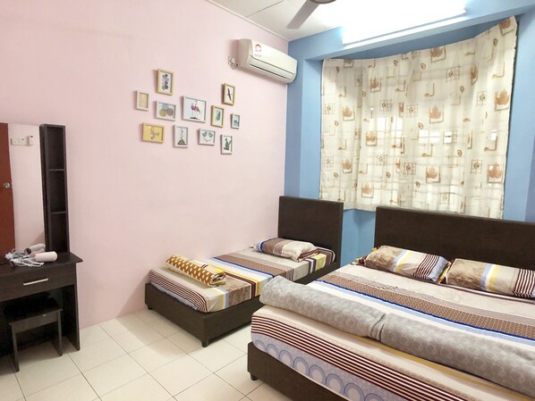 A bedroom with two beds, a dresser, a mirror, and a wall of framed pictures. - Sakura 2 Homestay Kampar (Kampar)