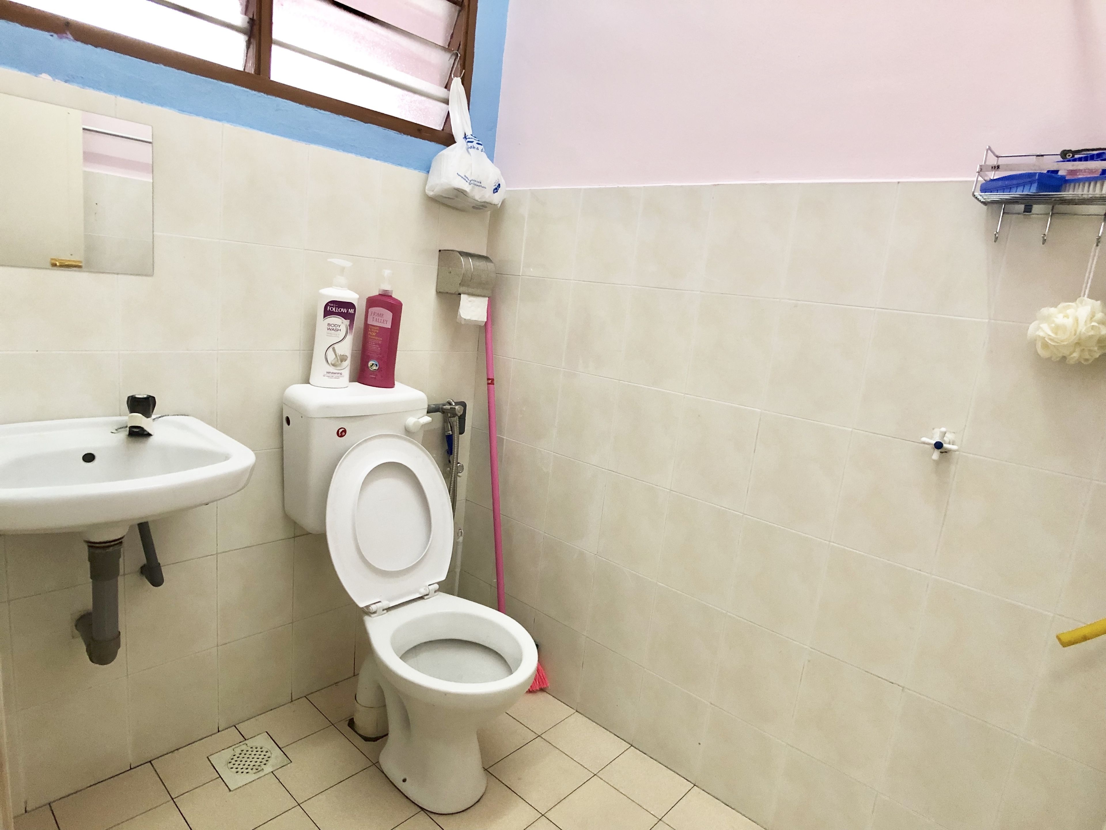 Et badeværelse med hvid vask, toilet og bruseniche.