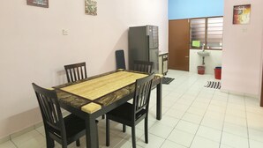 A dining area with a wooden table and chairs, a refrigerator, a sink, and a window with blinds. - Sakura 2 Homestay Kampar (Kampar)