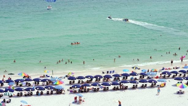 A beach with numerous umbrellas and sun loungers.