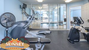 A gym with treadmills, a stationary bike, and a fan.