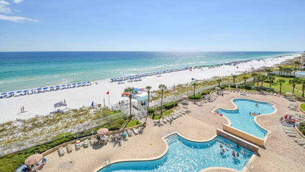 Un resort con una piscina grande, playa y vista al océano.