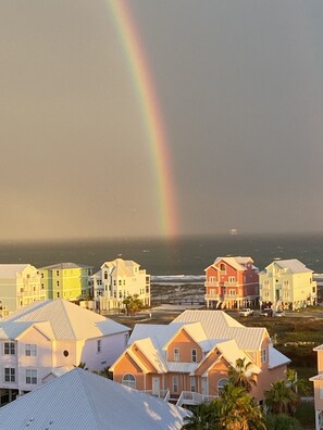 A coastal residential area with colorful houses and a visible rainbow.