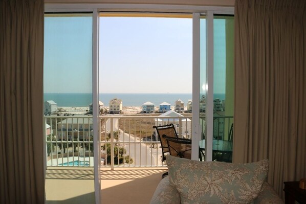 A balcony with a view of the sea and buildings.