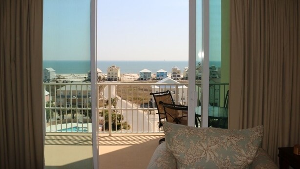 Ein Balkon mit Blick auf das Meer und die Gebäude.