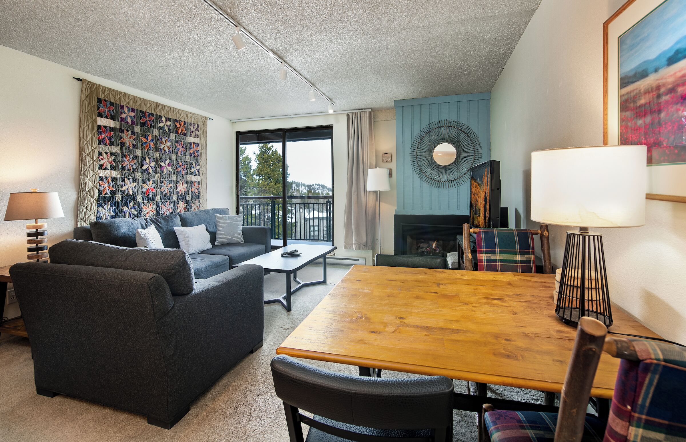 A cozy living room with a sofa, a wooden table, and a fireplace.