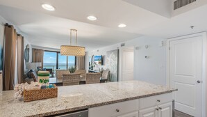 A modern kitchen with granite countertops, white cabinetry, and a built-in dishwasher. - Golf Cart ~ Gulf Views ~ Private Balcony (Miramar Beach)