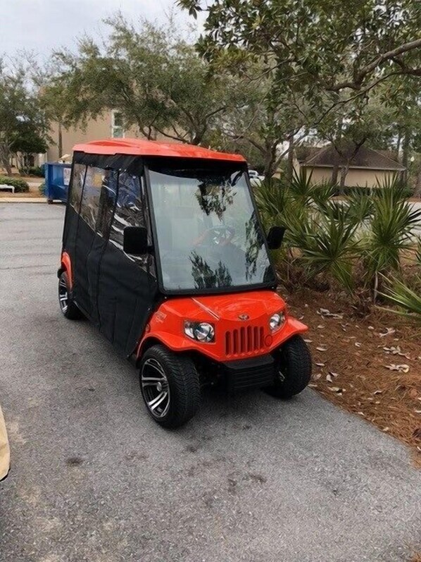 A red three-wheeled vehicle parked on a paved road. - Golf Cart ~ Gulf Views ~ Private Balcony (Miramar Beach)