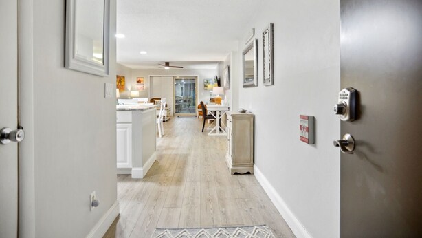 A hallway leading to a dining area with a kitchen in the background. - Surf Court 62 - Forest Beach 1st Floor Flat (Hilton Head Island)