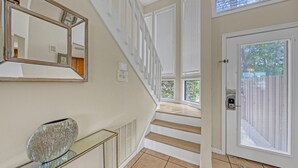 Eine Treppe führt zu einer zweiten Etage, am Ende befindet sich eine Glastür.