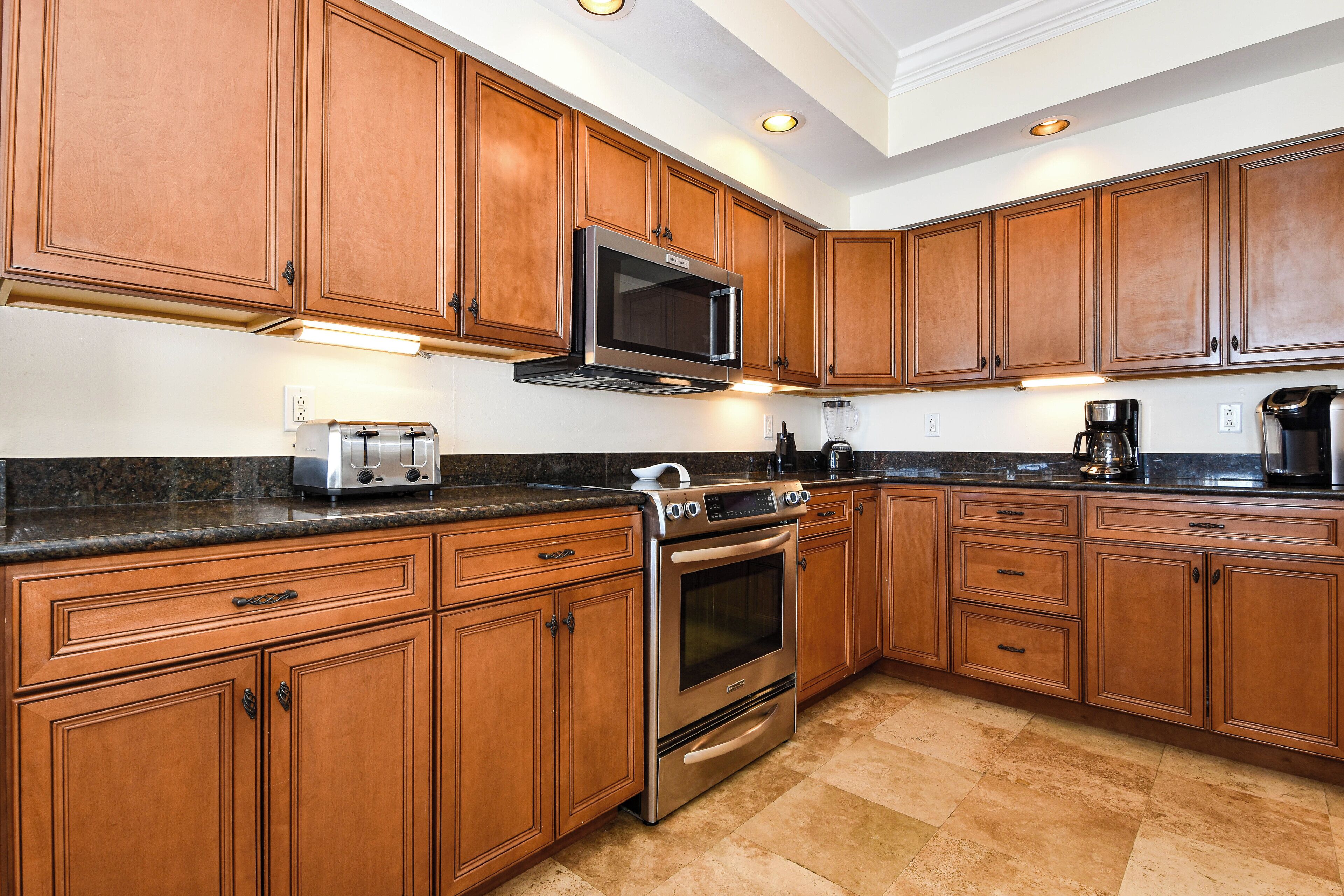 A kitchen with wooden cabinets, stainless steel appliances, and a granite countertop.