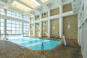 An indoor swimming pool with a tiled floor, large windows, and a high ceiling. - Two-story penthouse w/two private balconies! Majestic Sun 1106A (Miramar Beach)