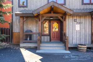 Traditional entrance with a red door and wooden porch, featuring a prominent building number 540.