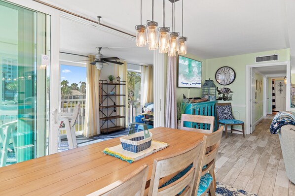 A dining area with a wooden table, chairs, a basket, and a hanging light fixture.