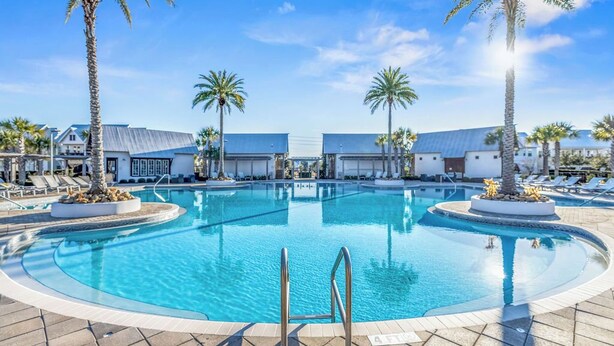 A swimming pool with lounge chairs and palm trees, surrounded by buildings. - Prominence on 30A - LSV Included - "Tipsea Kitty" - Virtual Tour (Rosemary Beach)