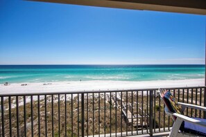 A balcony with a view of a beach and ocean.