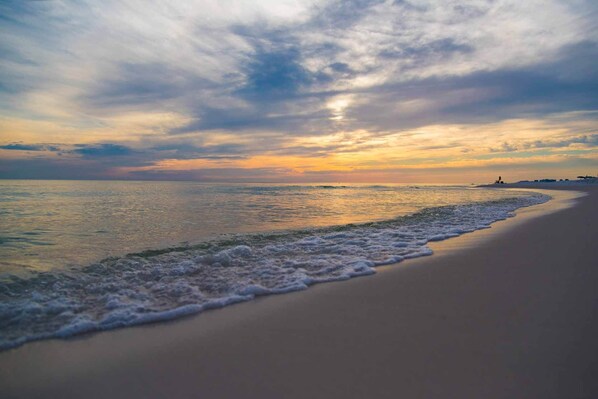A beach with a wide sandy shore and gentle waves.