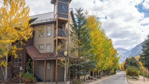 A building with a prominent clock tower, a street with autumn trees, and a mountainous backdrop. - Spacious Condo in Telluride-Beautiful West Views! (Telluride)