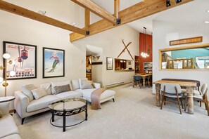 A spacious living room with a sofa, coffee table, and dining area.