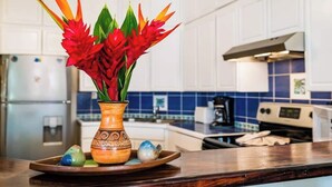 A kitchen with white cabinets, a blue tiled backsplash, and a wooden countertop.