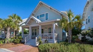 A two-story house with a porch, a front entrance, and a driveway. - Pet Friendly Prominence Home, Game Room, 4 Bikes, Sleeps 13 + Free Tickets! (Watersound)
