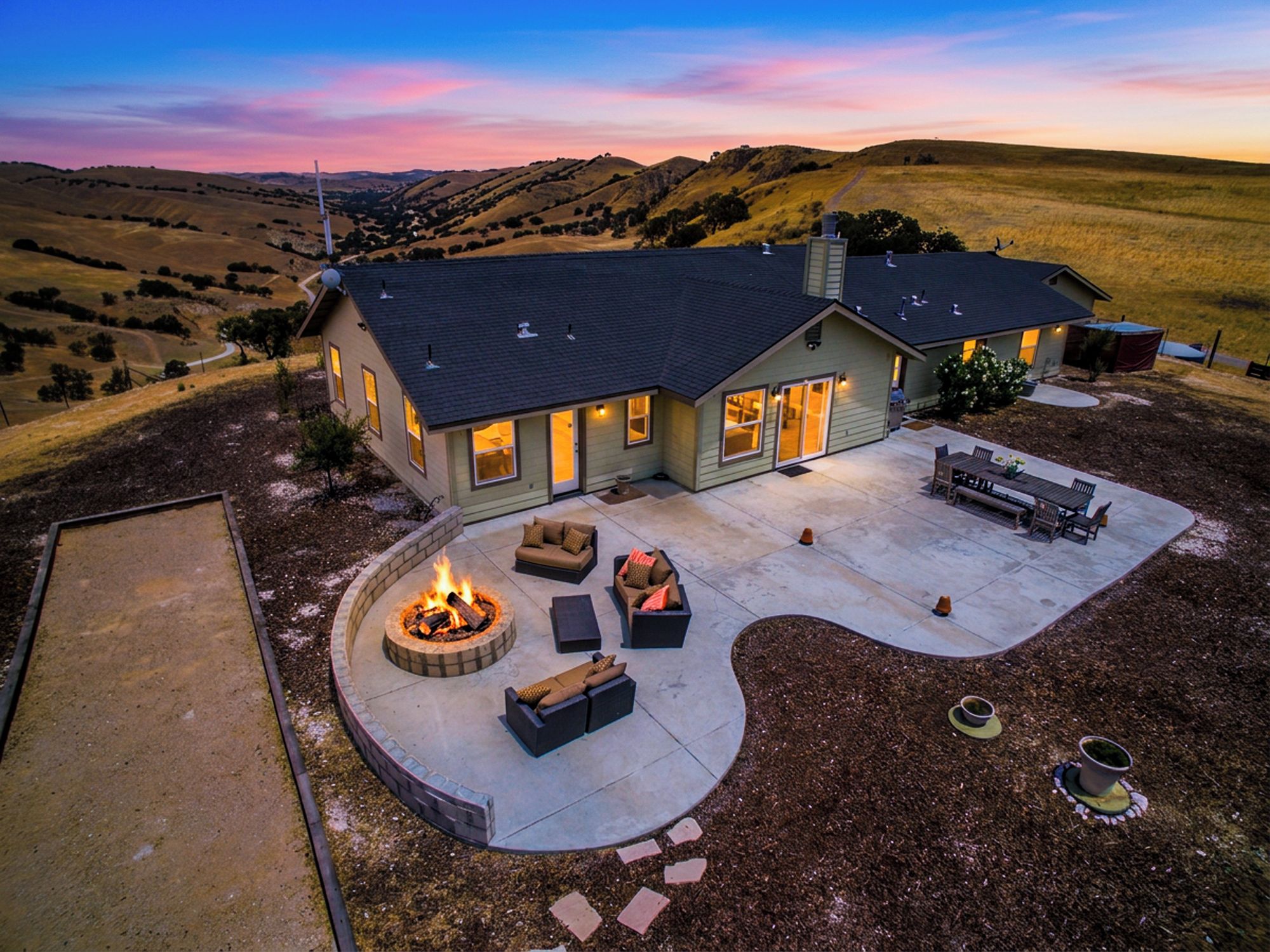 A house with a patio area featuring a fire pit and outdoor furniture.