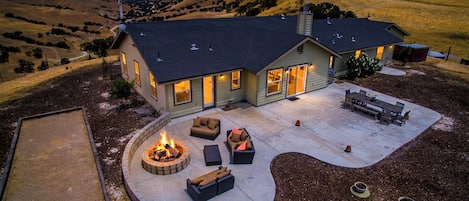 A house with a patio area featuring a fire pit and outdoor furniture.